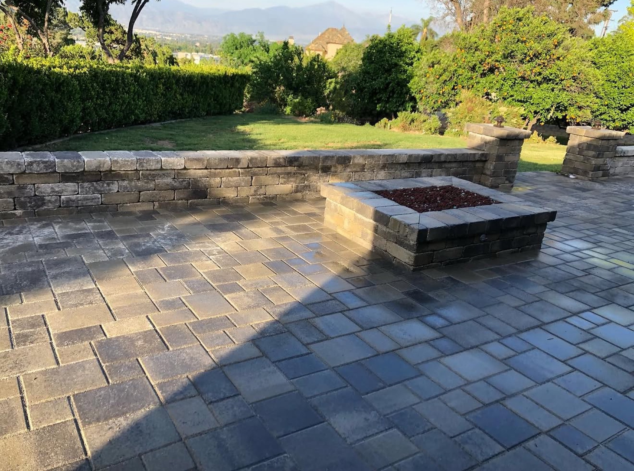 A finished B&M paver patio with fire pit and mountain views