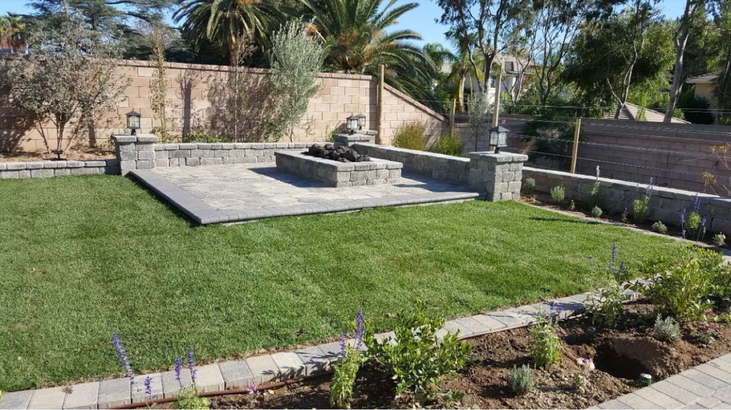 Fire-pit patio framed by fresh turf
