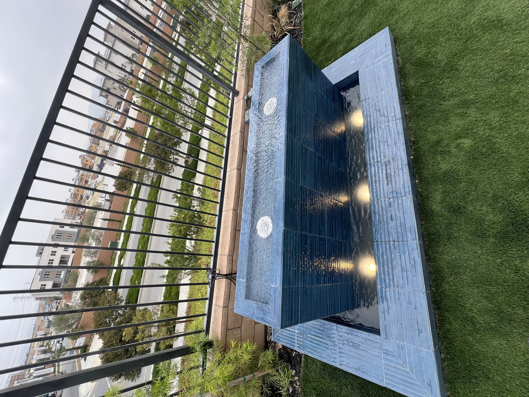 Glass-tile water feature with underwater lighting