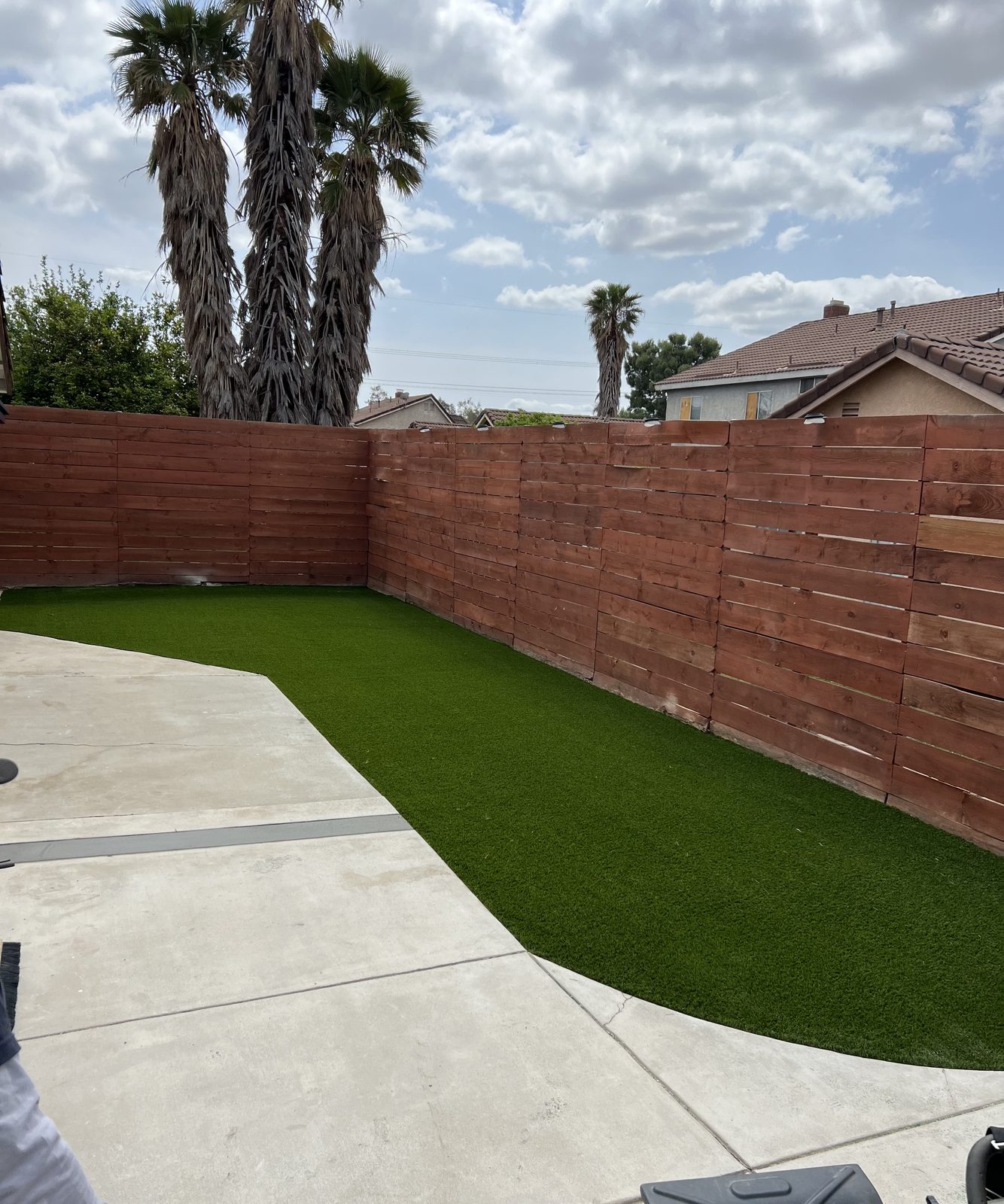 Side-yard turf run along a new redwood fence