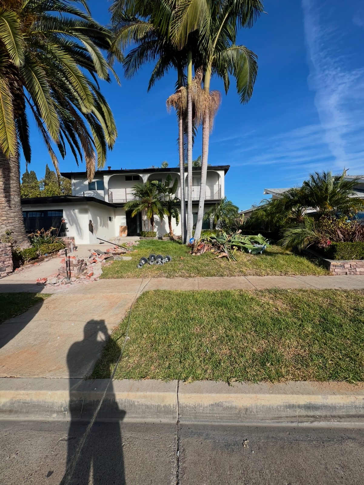 Before: Patchy lawn and old brick planter out. Turf, a new entry walk, and low walls we finished in smooth white stucco to match the house.