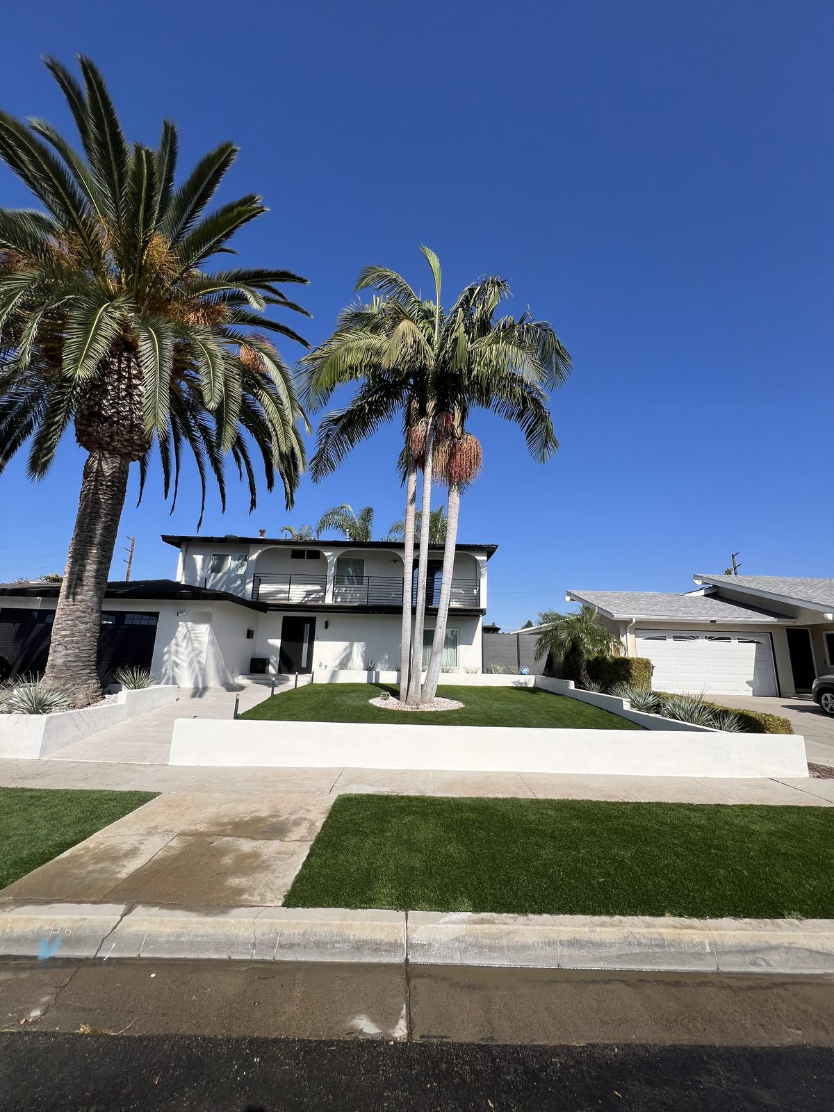 Front-yard turf finished with a low wall along the walk
