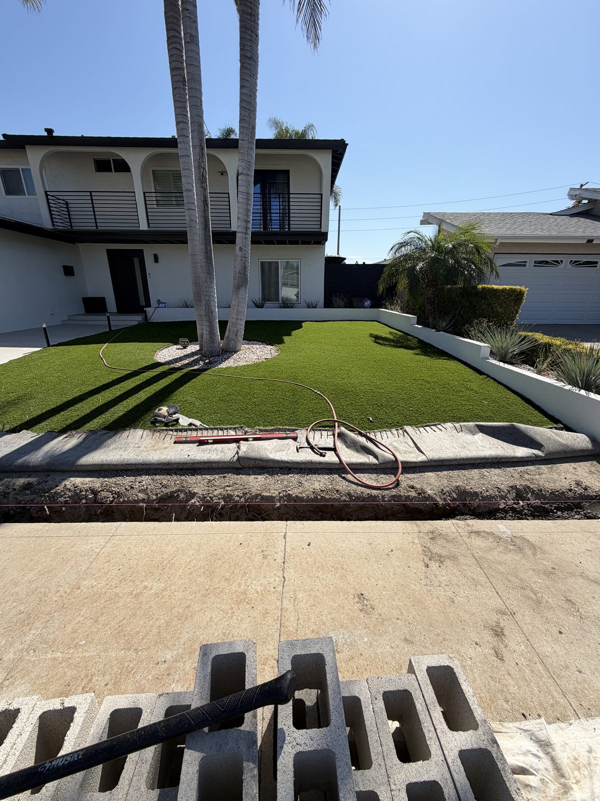 Same yard, same spot, sixteen months on. The turf had not moved, so they asked us to finish the front edge.